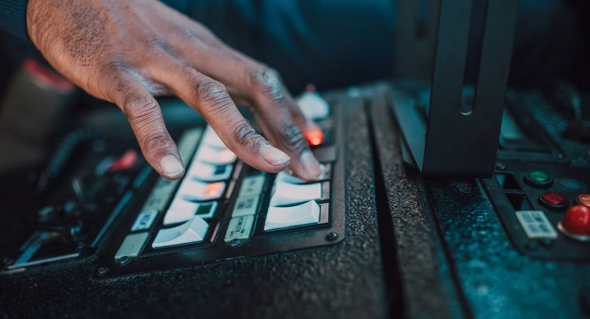 A close-up view of a hand manipulating switches on a control panel, showcasing technology interaction.