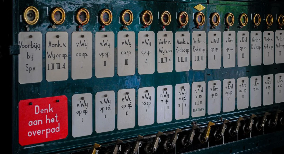 Close-up of a vintage Dutch mechanical control panel with labels.
