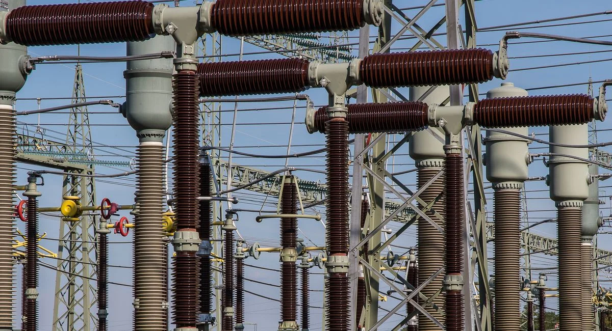 Detailed view of high voltage electrical substation with transformers and power lines.