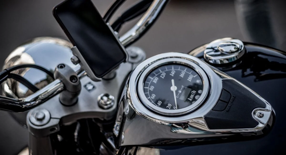 High-angle view of a motorcycle's speedometer and smartphone mount, capturing the essence of modern biking.