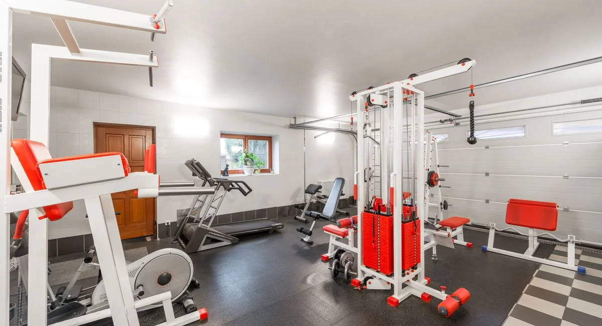Modern interior design of new spacious fitness gym for home sport training and heavy weightlifting in garage of big house